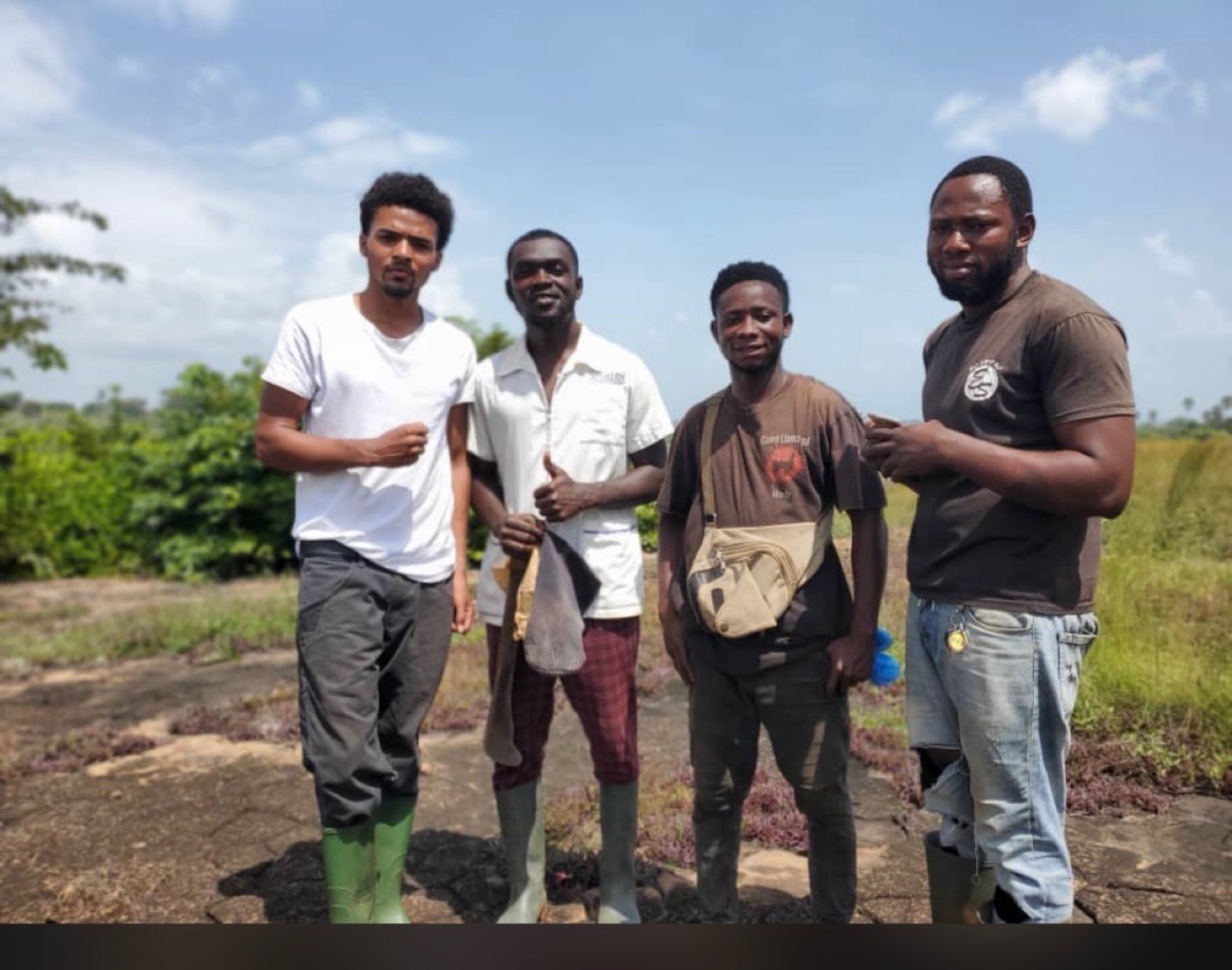 Kwame standing with three beekeepers in the field