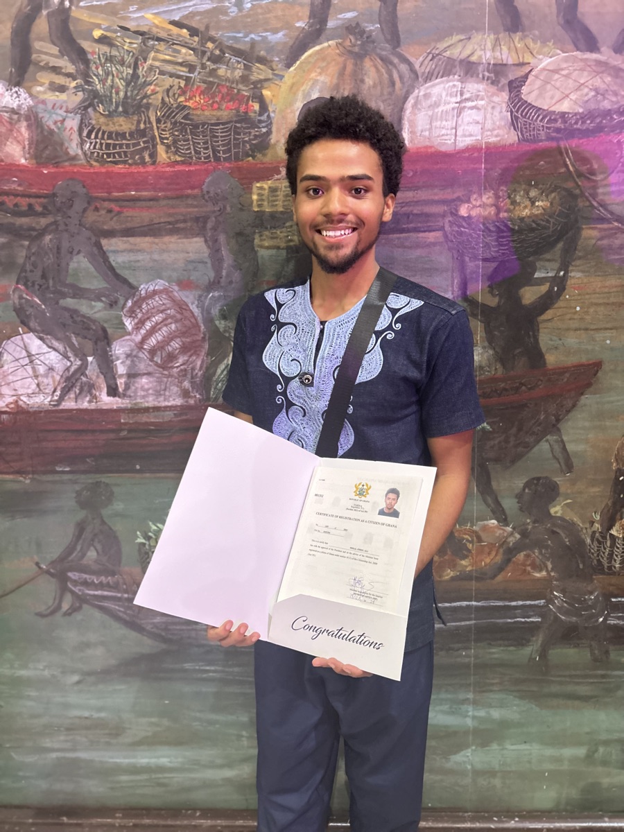 Kwame holding his certificate of registration as a citizen of Ghana