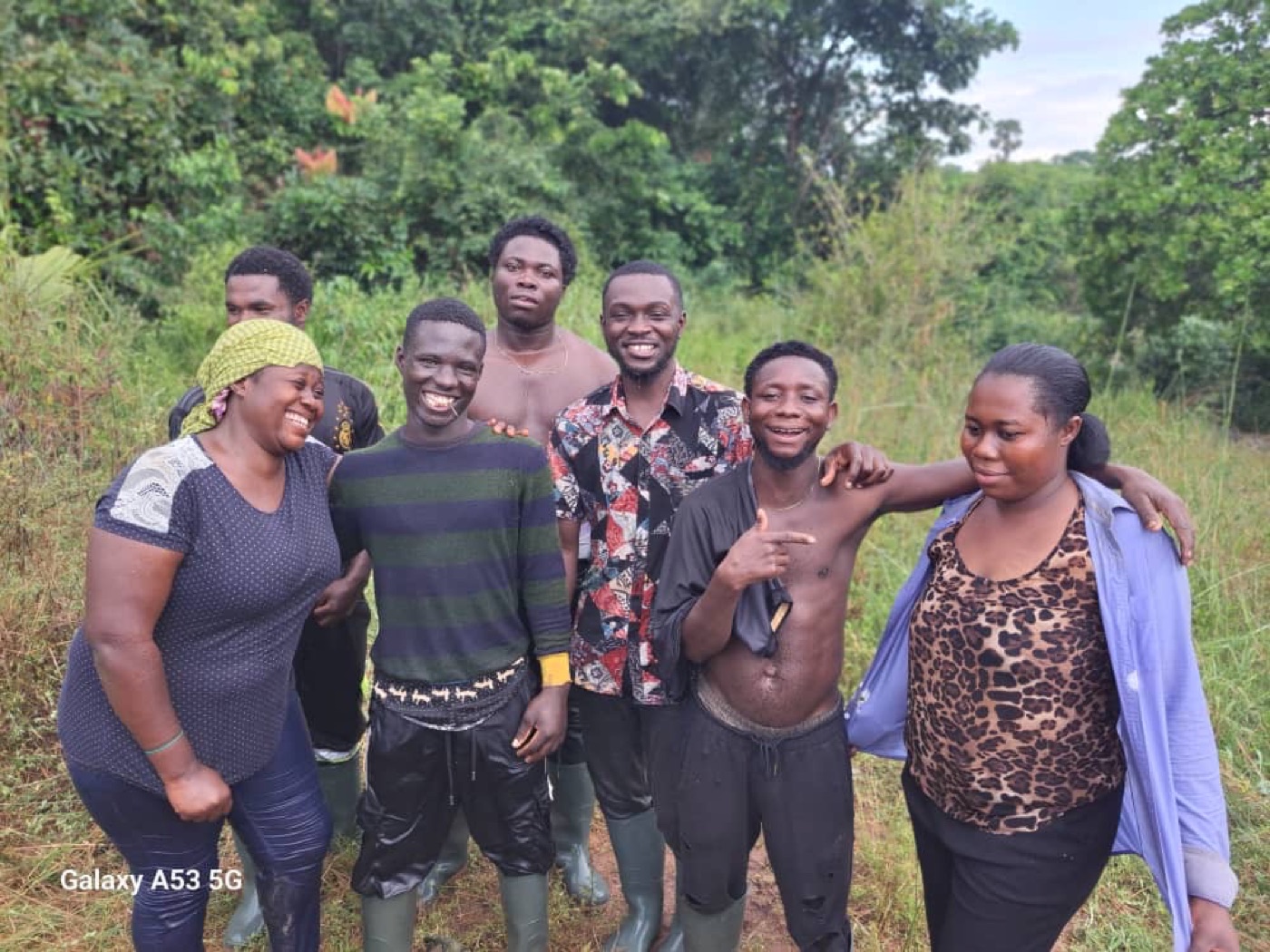 A laughing group of beekeepers in the bush after a harvest